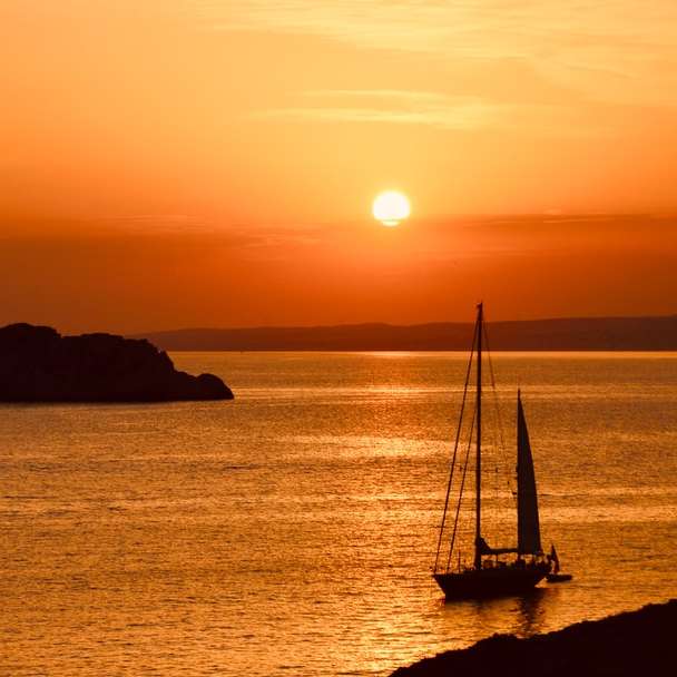Silhouette eines Segelboots auf dem Meer bei Sonnenuntergang Online-Puzzle