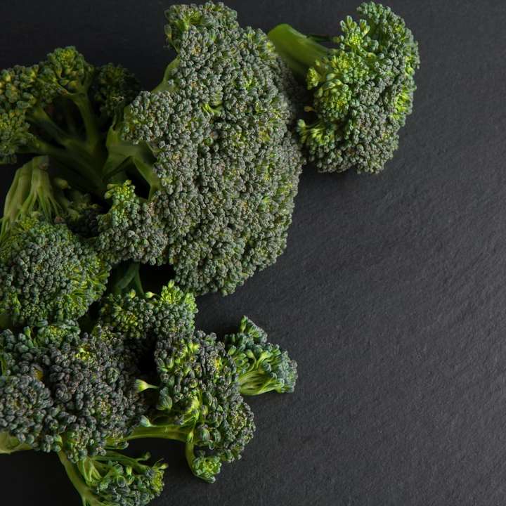 grön broccoli på svart textil Pussel online