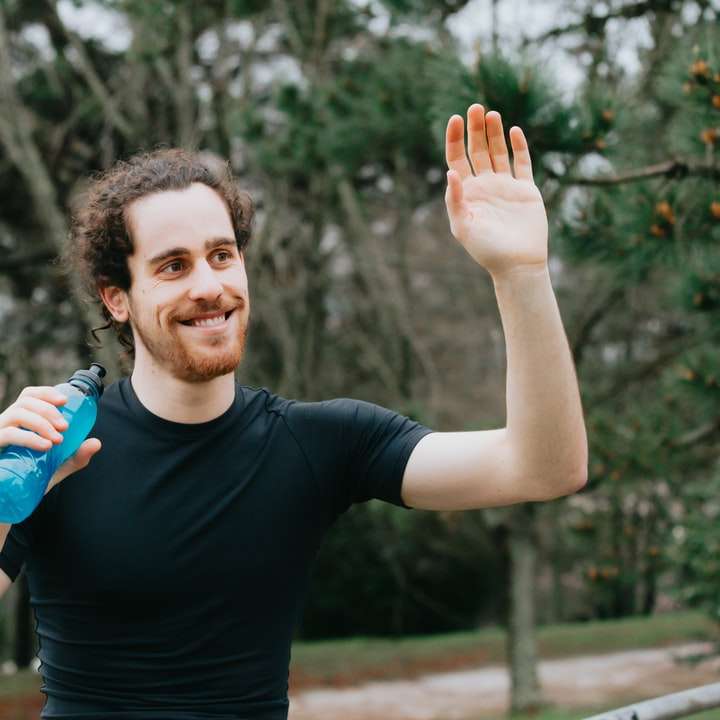 мъж в черна тениска с околен деколте и държи синя пластмасова бутилка онлайн пъзел