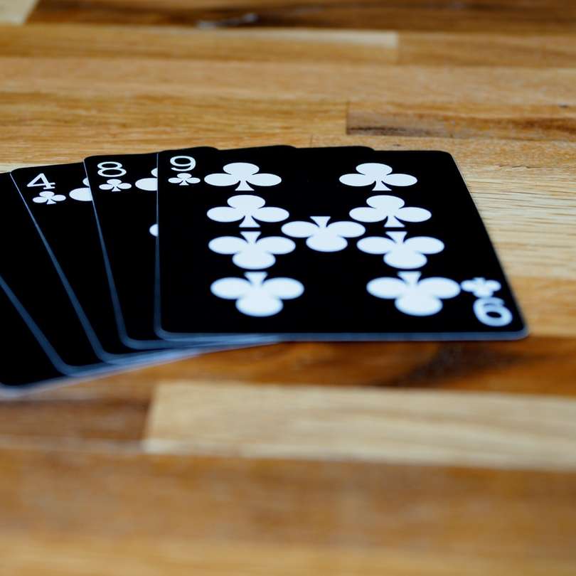 черно-белая игральная карта на коричневом деревянном столе онлайн-пазл