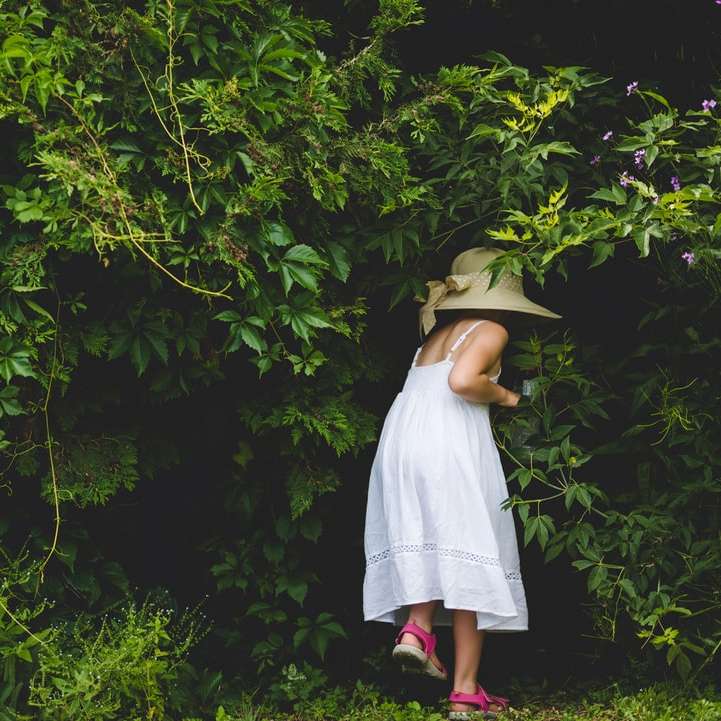 mulher de vestido branco em pé perto de árvores verdes puzzle deslizante online