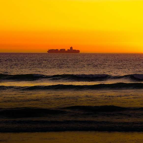 ondas do mar batendo na praia durante o pôr do sol puzzle online