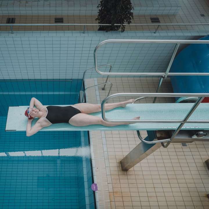 Mujer en pantalones cortos negros de pie junto a la piscina puzzle deslizante online