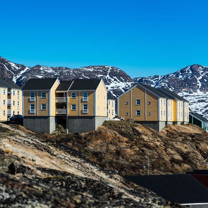 山の近くの白と茶色のコンクリートの建物 オンラインパズル