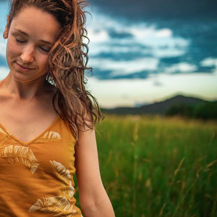 жена в жълт потник, стояща на зелено тревно поле онлайн пъзел