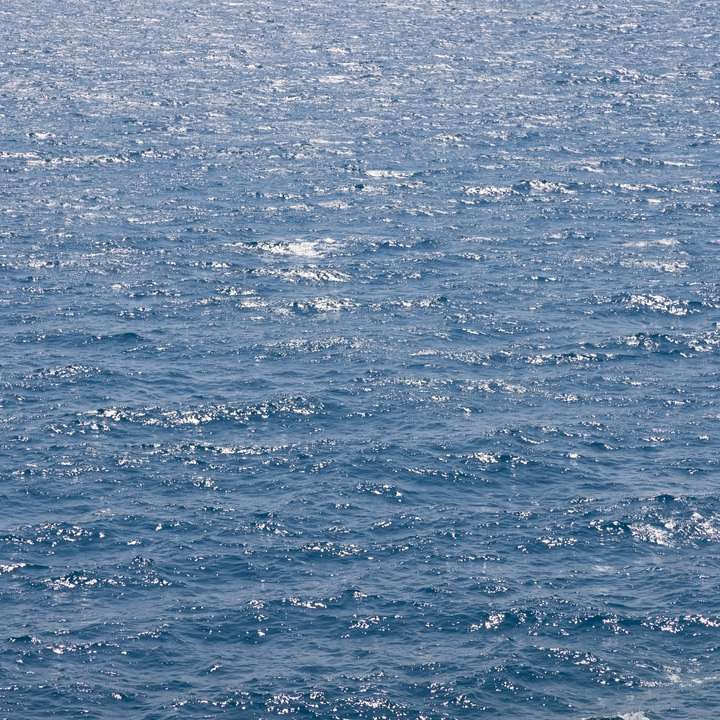 Blått havsvatten under dagtid glidande pussel online