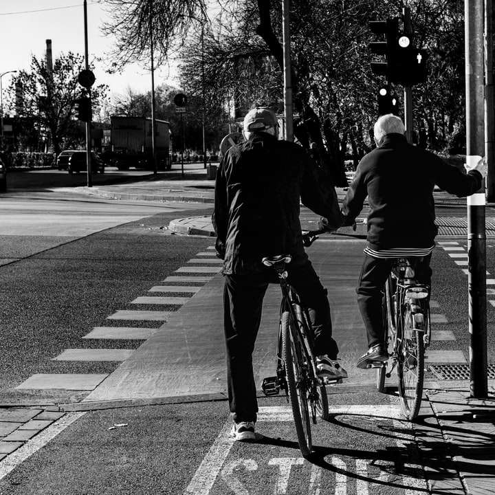 grijswaardenfoto van mensen die op de weg fietsen schuifpuzzel online