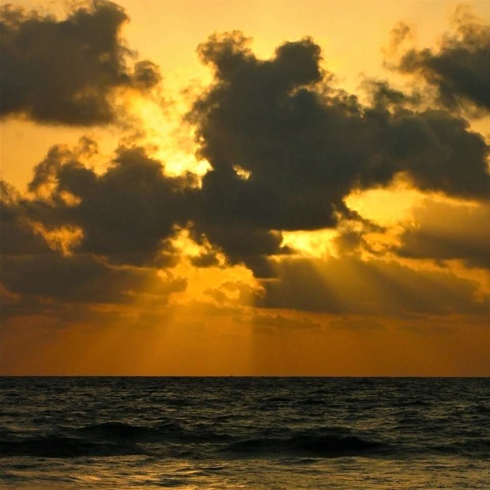 waterlichaam onder bewolkte hemel tijdens zonsondergang schuifpuzzel online