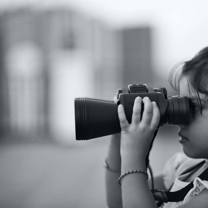 gråskalefoto av barn som använder kikare Pussel online