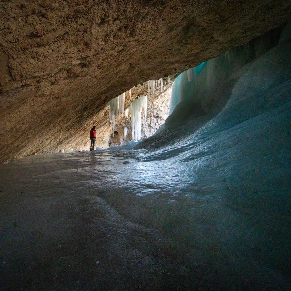persona con camisa blanca caminando dentro de la cueva rompecabezas en línea
