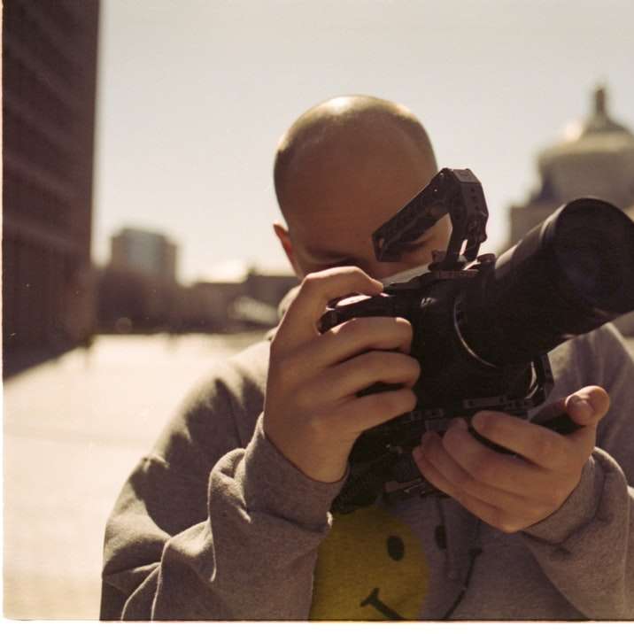 Garçon en manteau beige tenant un appareil photo reflex numérique noir puzzle coulissant en ligne
