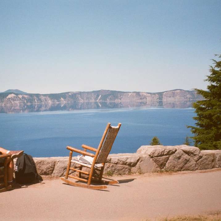 2 особи сидять на коричневих дерев'яних кріслах-гойдалках розсувний пазл онлайн