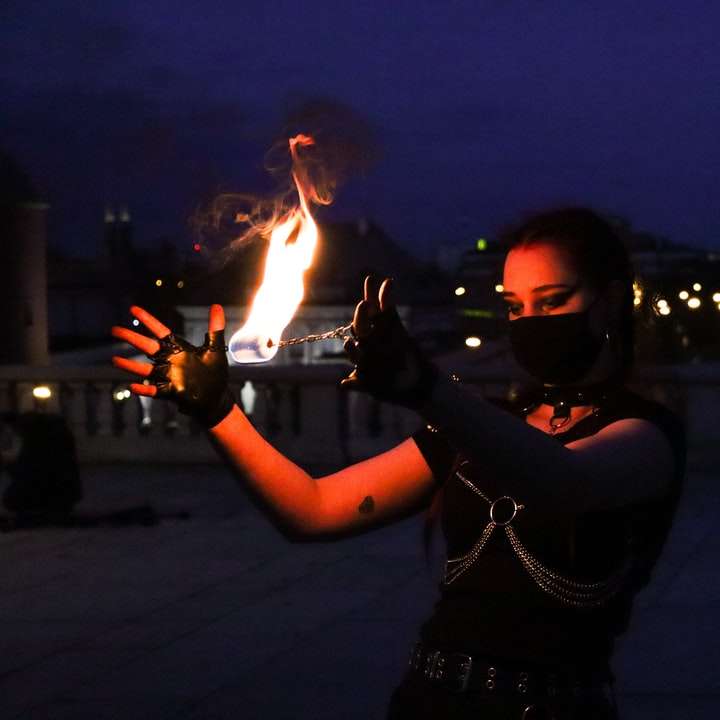mulher de camisa preta de manga comprida segurando fogo puzzle deslizante online