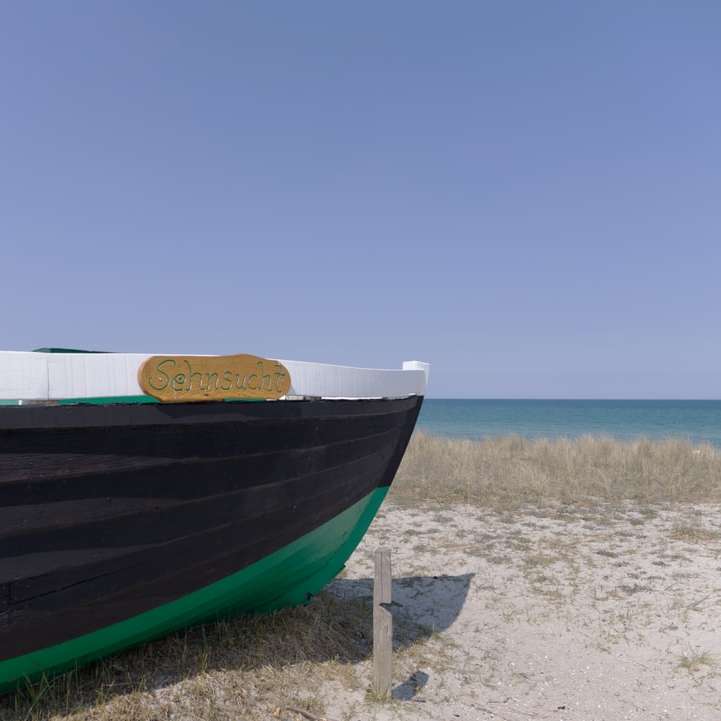bateau bleu et blanc sur le rivage de la plage pendant la journée puzzle coulissant en ligne