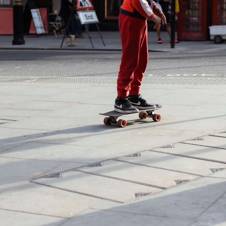 homme en pantalon rouge et chaussures noires équitation skateboard puzzle coulissant en ligne