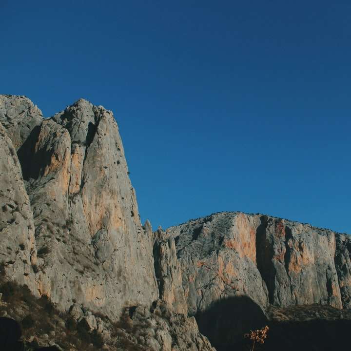 昼間の青い空の下で茶色の岩の形成 スライディングパズル・オンライン