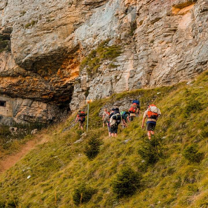 personnes faisant de la randonnée sur une montagne rocheuse pendant la journée puzzle en ligne