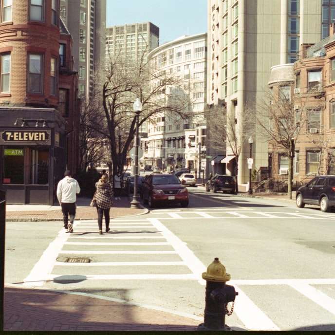 persone che camminano sul marciapiede vicino a edificio in cemento marrone puzzle online
