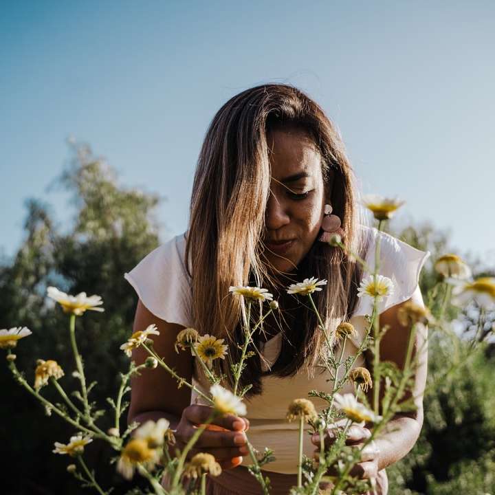 femeie în cămașă albă ținând flori albe alunecare puzzle online