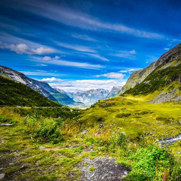 campo de grama verde e montanhas sob o céu azul puzzle online