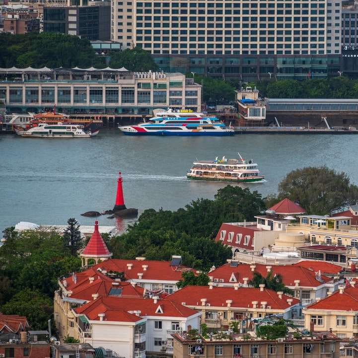 fehér és kék csónak a vízen városi épületek közelében csúszó puzzle online