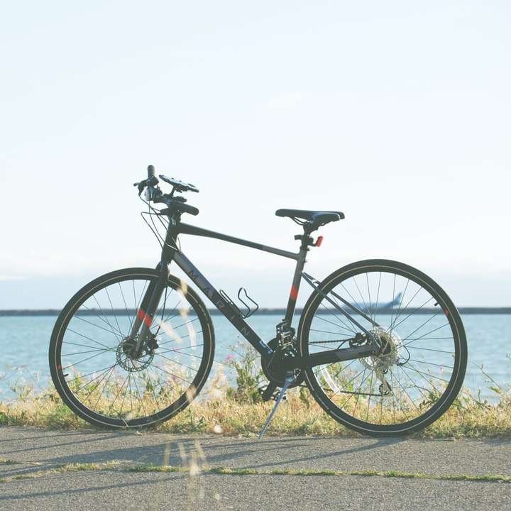bicicleta rutieră neagră și gri pe drum de beton gri lângă caroserie puzzle online