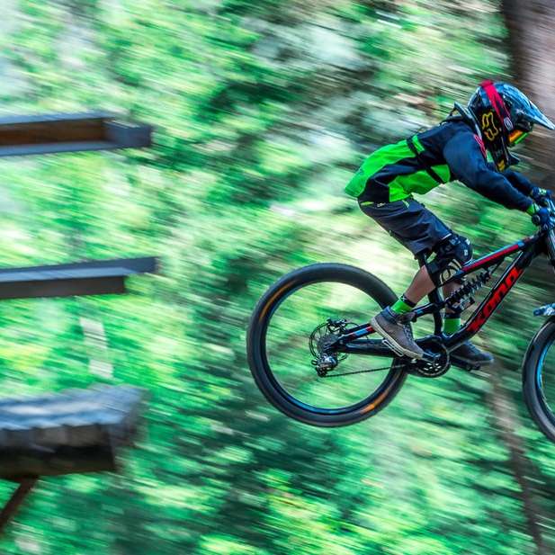 man riding on black and orange mountain bike in forest sliding puzzle online