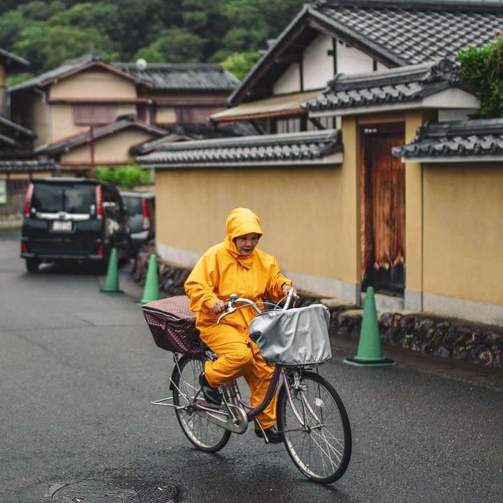 Mann in gelber Jacke, der tagsüber Fahrrad auf der Straße fährt Schiebepuzzle online