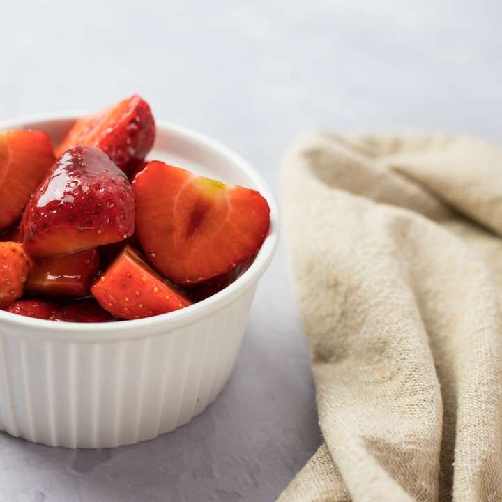 skivade jordgubbar i vit keramisk skål Pussel online