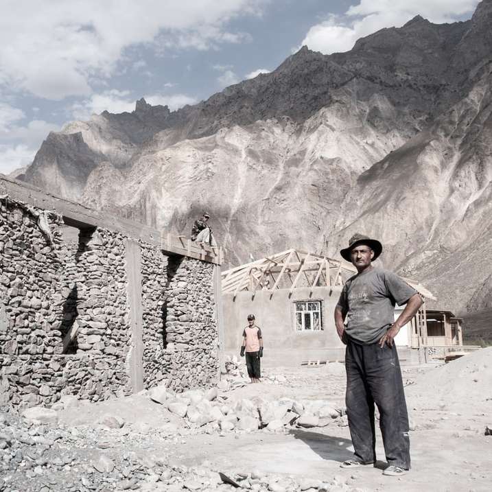 Mann in schwarzer Jacke, der in der Nähe einer braunen Felsformation steht Online-Puzzle