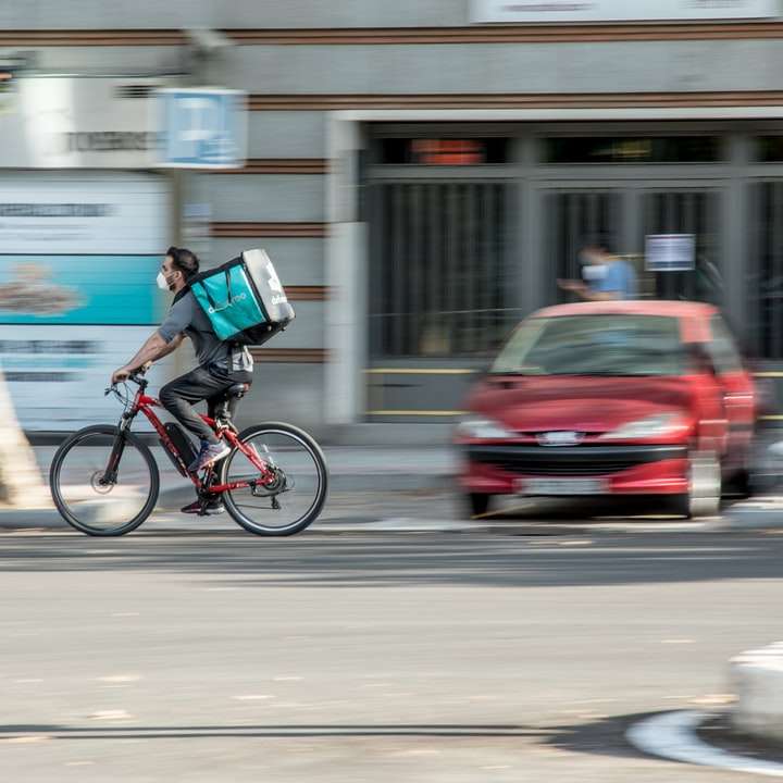 bărbat în cămașă albastră călare cu bicicleta pe drum în timpul zilei alunecare puzzle online