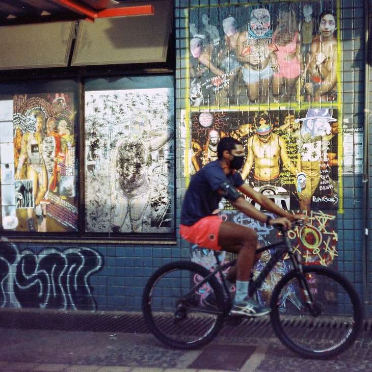чоловік у синій футболці з круглим вирізом їздить на чорному велосипеді розсувний пазл онлайн