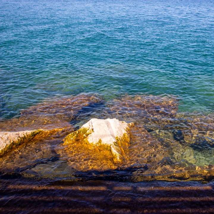 bruin gesteente op het water overdag schuifpuzzel online