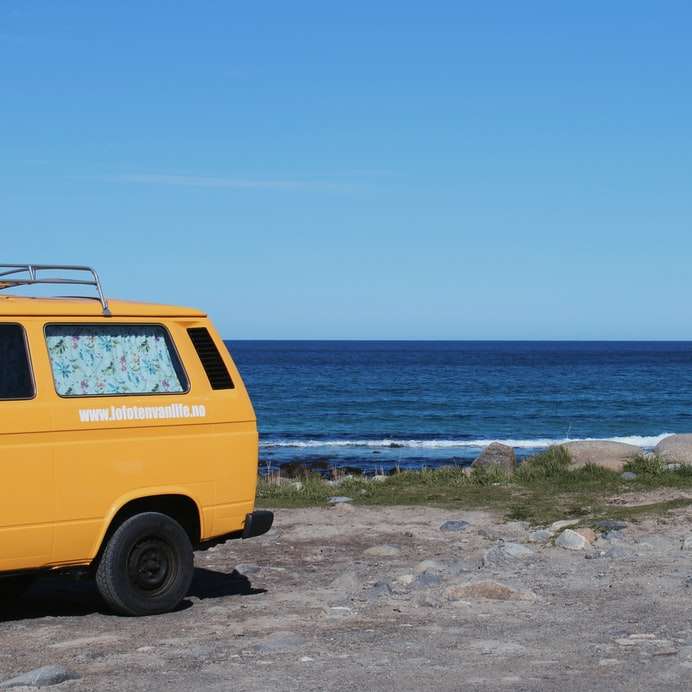 yellow van on beach shore during daytime sliding puzzle online