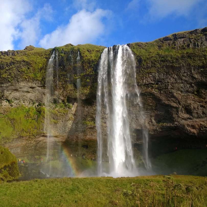 wodospady na zielonym polu trawy pod błękitnym niebem puzzle online