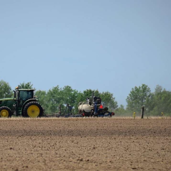 зеленый трактор на коричневом поле в дневное время онлайн-пазл
