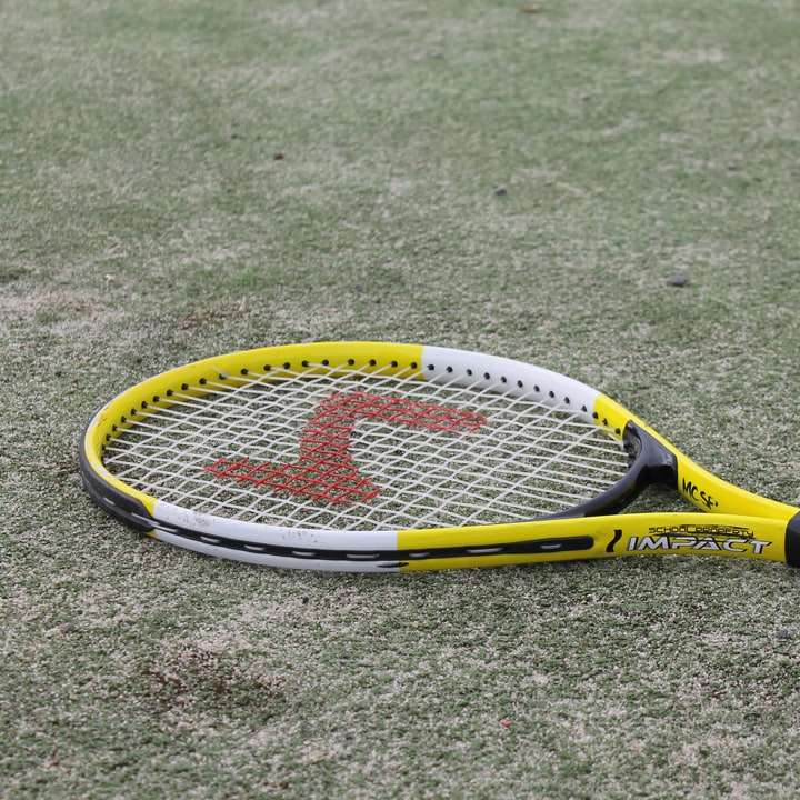 жълта и черна тенис ракета на зелена трева онлайн пъзел