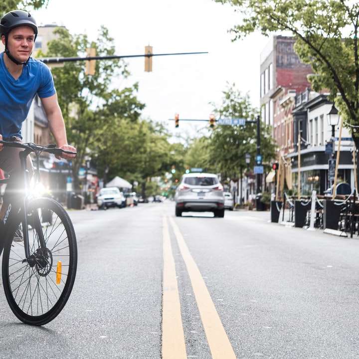 道路で自転車に乗る青い乗組員の首のTシャツの男 スライディングパズル・オンライン
