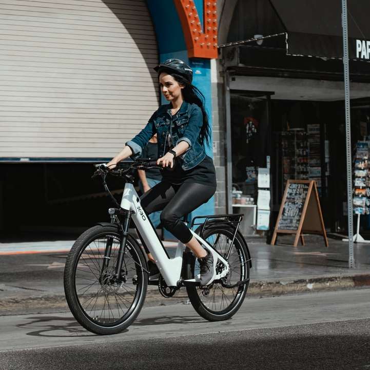 mulher de jaqueta jeans azul andando de bicicleta preta puzzle online