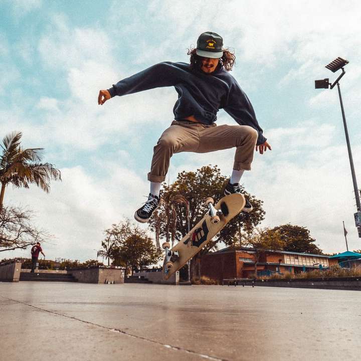 άνδρας με μαύρο πουκάμισο και καφέ παντελόνι που κάνει skateboard συρόμενο παζλ online