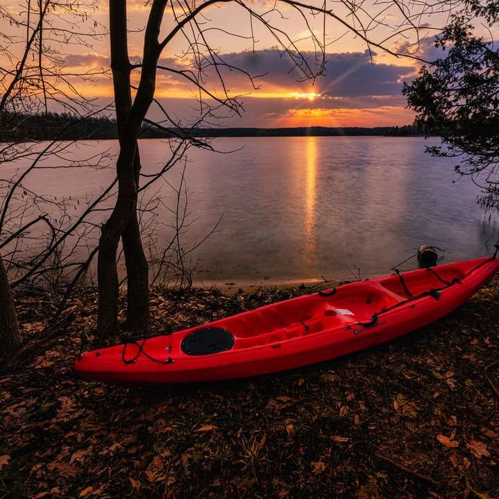 czerwony kajak na jeziorze podczas zachodu słońca puzzle przesuwne online