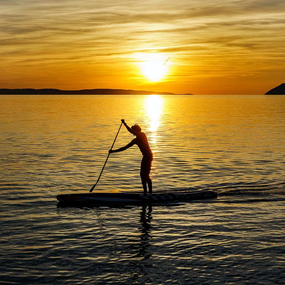 homme sur kayak pendant le coucher du soleil puzzle coulissant en ligne