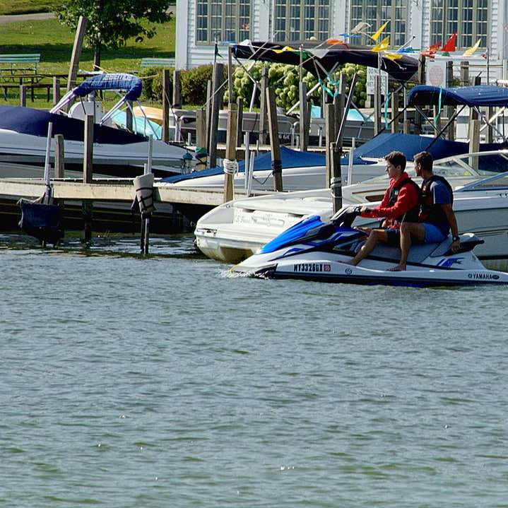 Mann im roten Hemd reitet auf einem weißen und blauen Boot Online-Puzzle