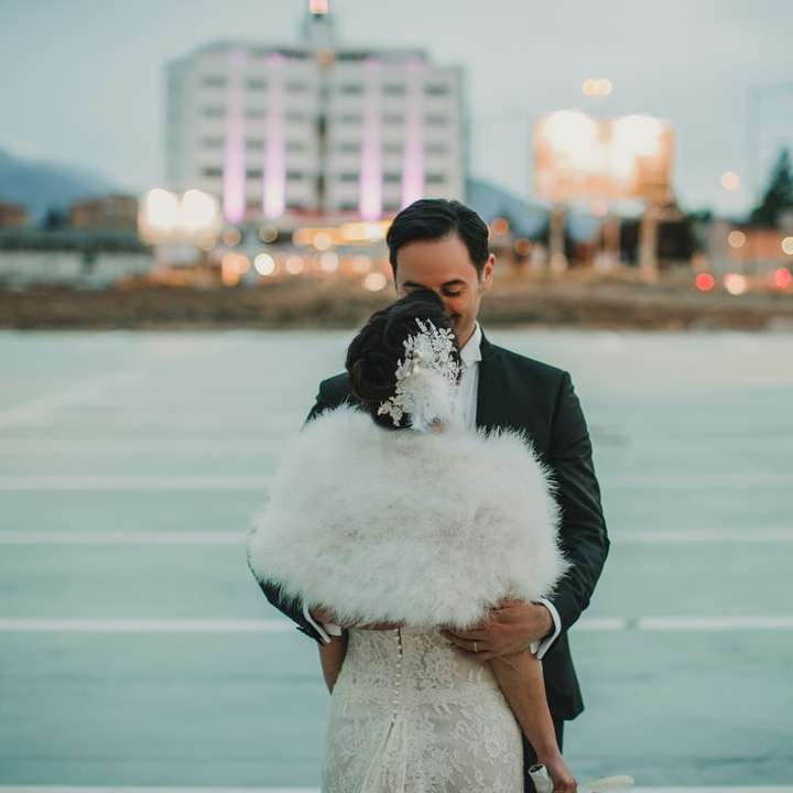 Mann im schwarzen Anzug küsst Frau im weißen Hochzeitskleid Schiebepuzzle online