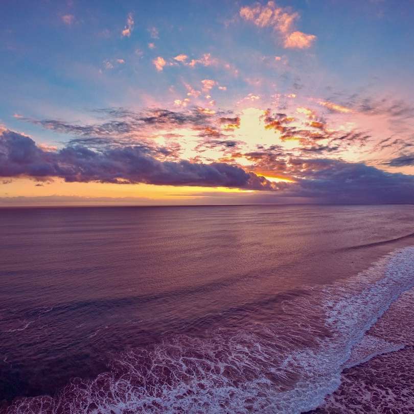 Olas del mar rompiendo en la orilla durante la puesta de sol rompecabezas en línea