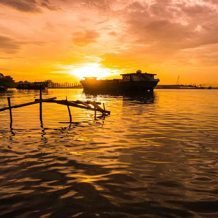 Schattenbild des Bootes auf See während des Sonnenuntergangs Online-Puzzle