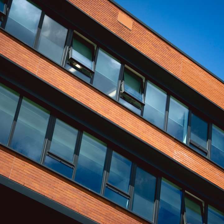 brun betongbyggnad under blå himmel under dagtid Pussel online