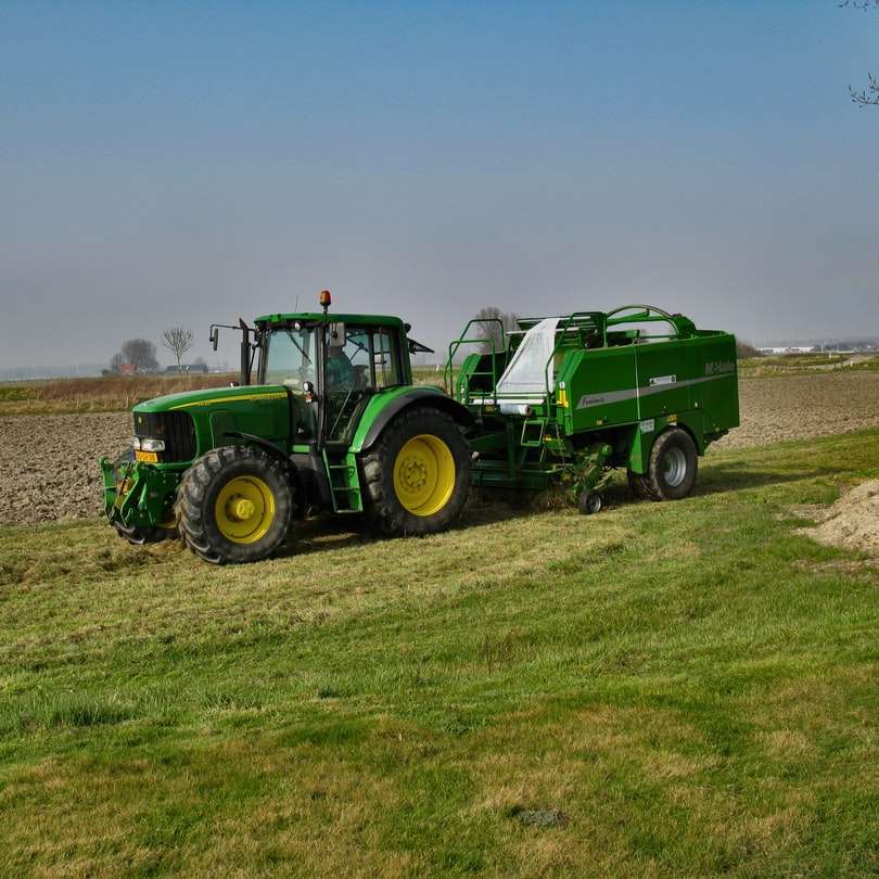 Tractor verde pe câmpul de iarbă verde sub cer alb alunecare puzzle online