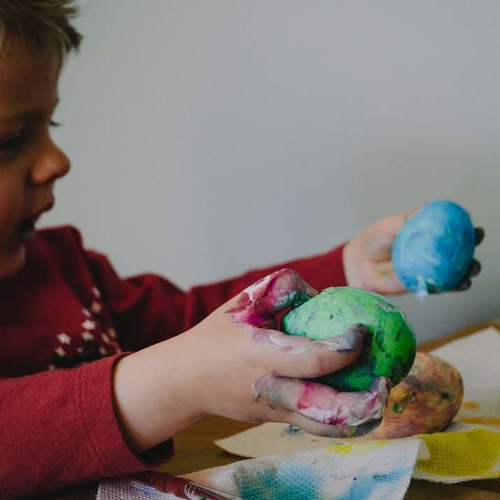 menino segurando cascas de ovo pintadas de azul e verde puzzle online