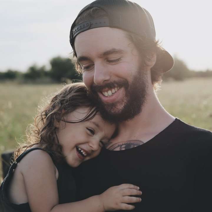 мъж, носещ дъщеря в черен топ без ръкави онлайн пъзел